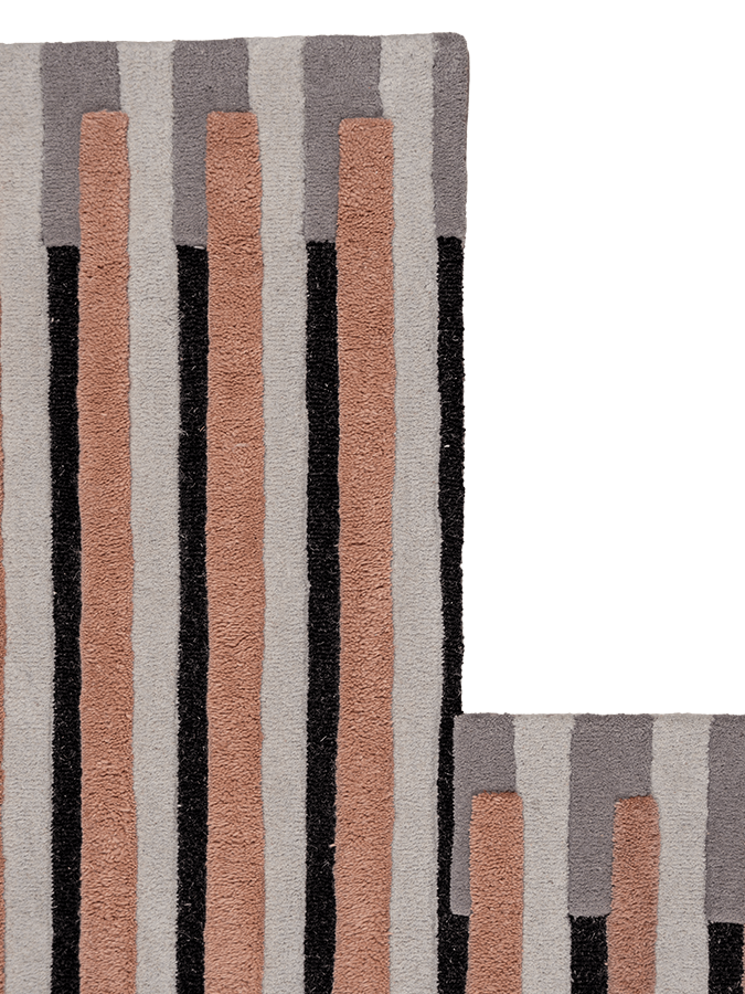 Still Movement hand-tufted rug detail showing the sculptural high low pile and the sophisticated transition between neutral stone and warm clay shades.