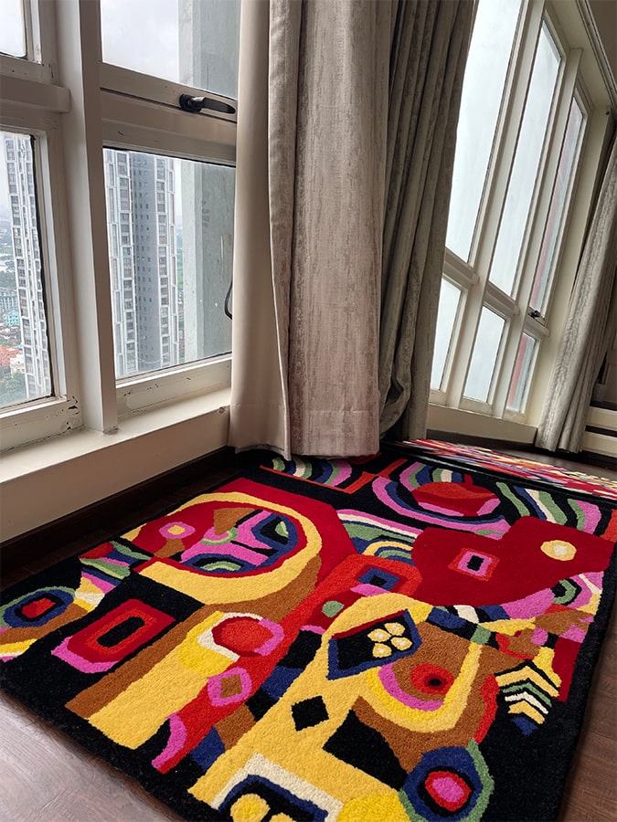 The Ambivalence Rug displayed in a living area, showcasing its vibrant mixed colors and soft texture, hand-tufted from New Zealand wool.