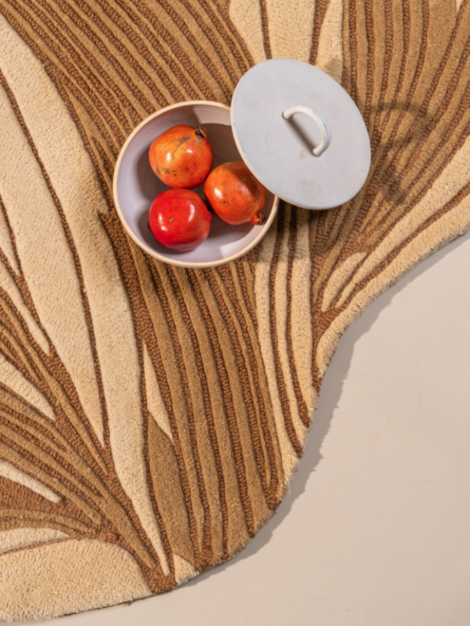 Hand-tufted rug inspired by organic stone veins in neutral and golden tones.