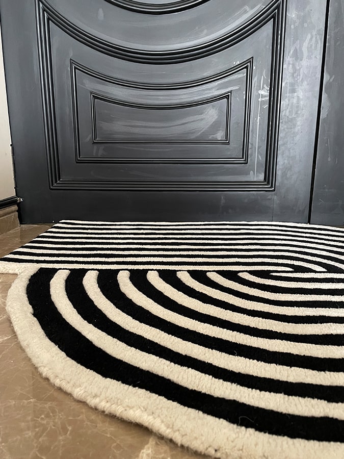 Angle view of the Movement Rug on the floor, showcasing how it enhances the room with a warm, sophisticated feeling.