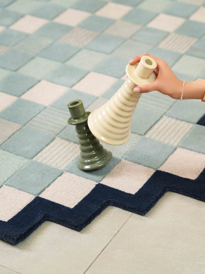 Textured wool rug in pastel tones with geometric pixel design.
