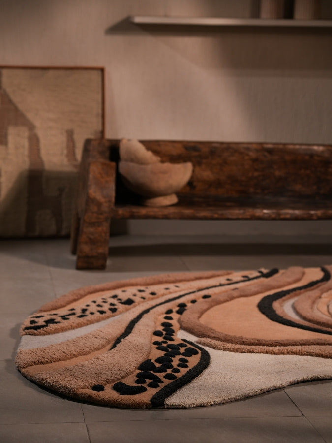 Sandstorm textured rug featuring soft beige, tan, and charcoal swirls inspired by desert dunes.