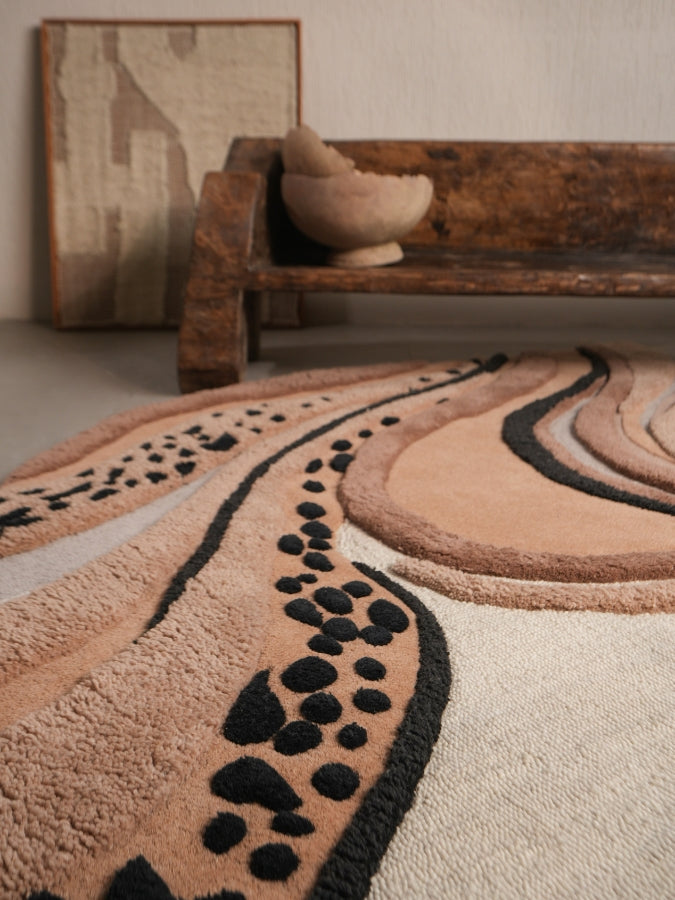 Sandstorm textured rug featuring soft beige, tan, and charcoal swirls inspired by desert dunes.