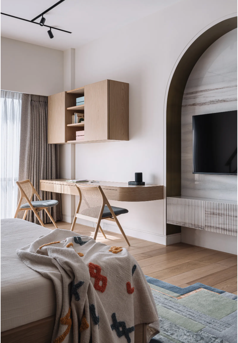 Partial view of the Skyline rug showing blue edging and textured geometric panels beside a bed facing a study desk